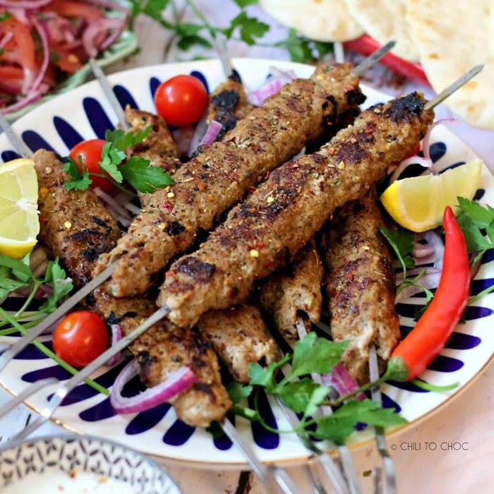 Student cooking kebabs in a tandoor class